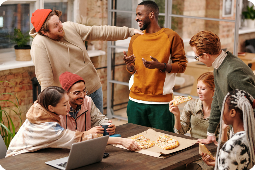 a group of people gathering and having a good time while having pizzas.