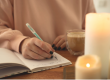 A person writing on a journal.
