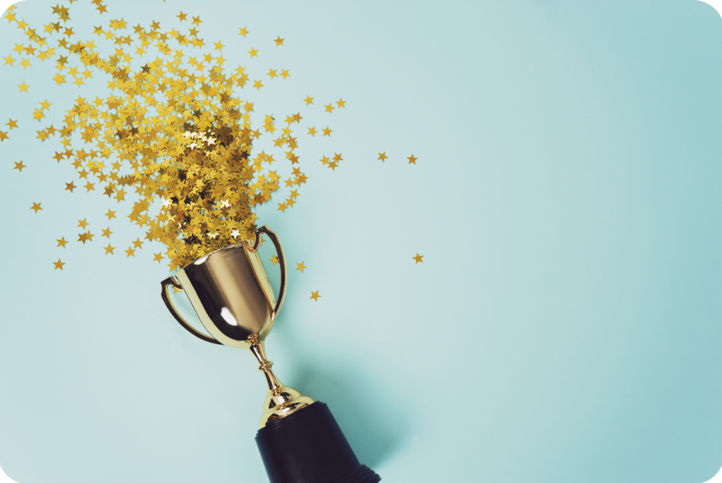 Star-shaped confetti coming out of a gold trophy.