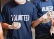 A picture of two people wearing a navy blue shirt with a word Volunteer.
