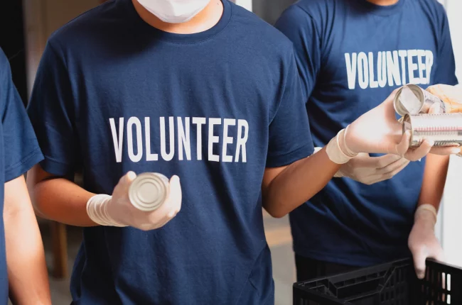 Blog-volunteer A picture of two people wearing a navy blue shirt with a word Volunteer.